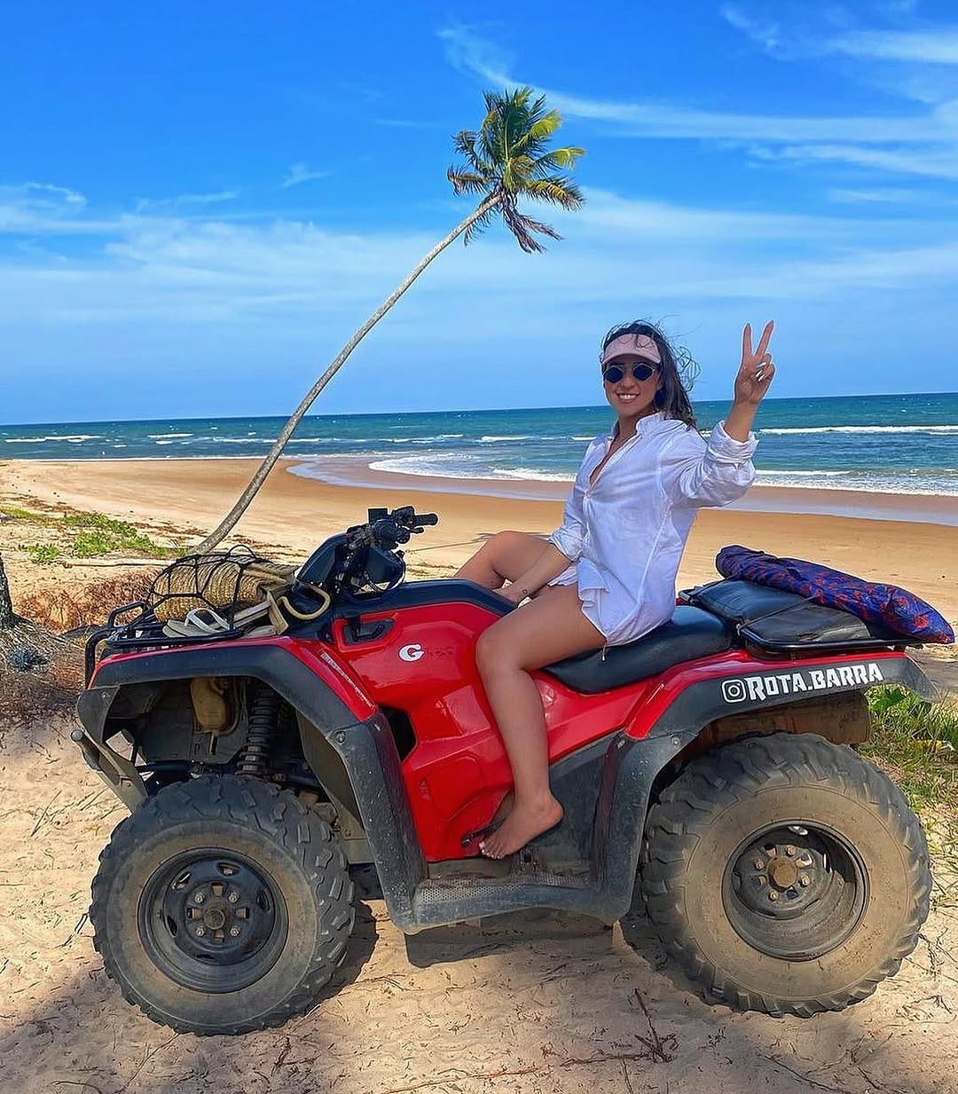 Viajante em um quadriciclo diante de uma praia da Península de Maraú